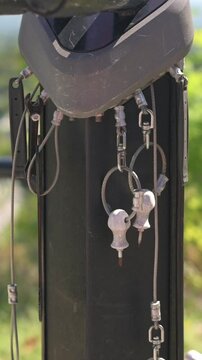 Verti al screen closeup helmet and keys ready on park post during morning commute, keyring swinging against textured metal, bright daylight and green backdrop, energetic urban routine vibe