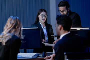 Data integrity check night shift Diverse team meticulously audits financial performance comparing...