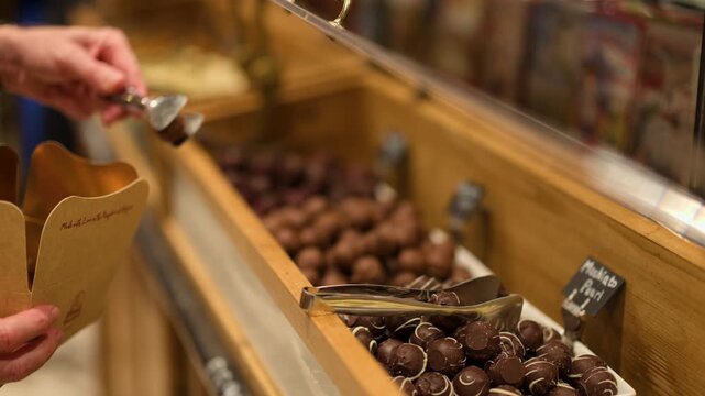 Selecting Chocolates at Evening Shop Display in Bruges