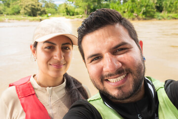 Obraz premium Portrait of a Colombian couple smiling while sailing on the Magdalena River during the day in Villavieja, Huila, Colombia. Concept of tourism and vacations