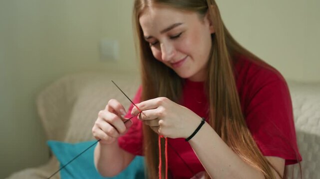 casual woman practicing knitting at home, relaxed female enjoying knitting in cozy apartment setting, friendly woman with beginner skills knitting in modern living room environment