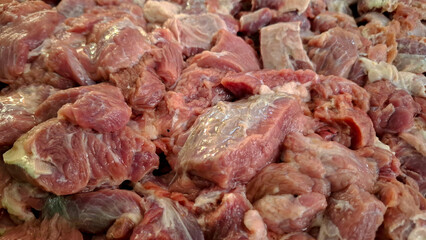 Detailed close-up of raw beef meat pieces showing natural fibers, fat layers, and fresh texture