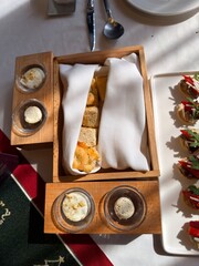 Bread basket with butter and spreads on dinner table