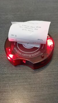 Wireless calling system with red light indicator turning on when food is ready, restaurant pager notification device for service alert and customer pickup.