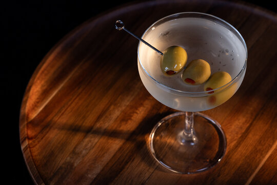 beautiful and dramatic lighting on a dirty martini with 3 olives