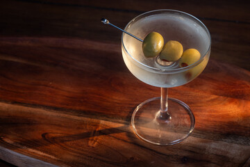 beautiful and dramatic lighting on a dirty martini with 3 olives