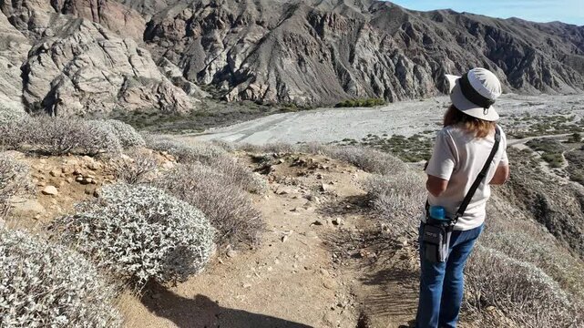 A Pair of Naturalists exploring the Whitewater River in California as the hike through the rocky habitat with a woman on the trail