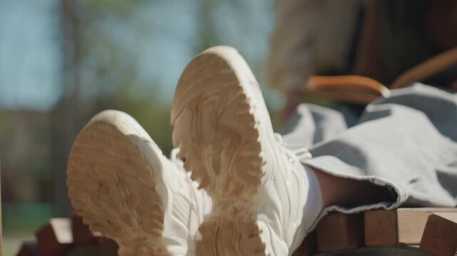 sunlit shoes and reading scene, leisurely shoes placed outdoors with reading and sunlight warmth, tranquil scene featuring footwear resting in sunny outdoor environment with reading materials