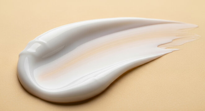 Close up captures a creamy white swirl on a golden surface, perfect for cosmetic or beauty concepts. The texture is smooth, highlighting lotion or skin care.