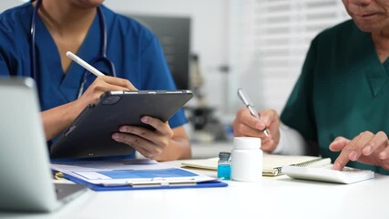 Medical team working with a tablet and Laptop computer search for medical information at the hospital office. - Powered by Adobe