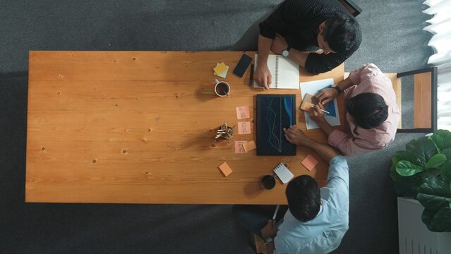 Group of diverse people sharing idea while writing at colorful sticky notes. Top down view of smart business team brainstorming idea and planning strategy for startup project. Time lapse. Convocation. - Powered by Adobe