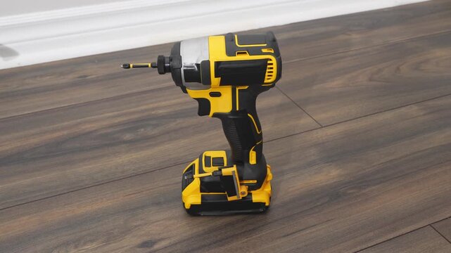 Power drill is positioned on wooden floor, showcasing its design and functionality, highlighting tool features and craftsmanship in action