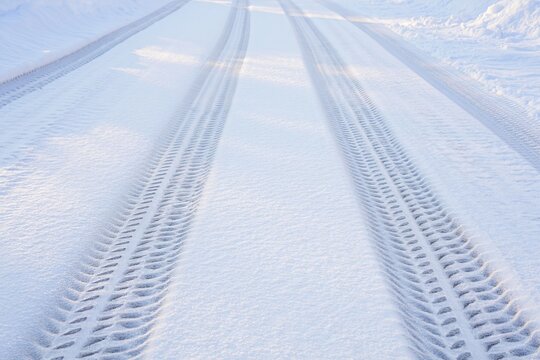 Fototapeta Tire tracks deeply pressed into fresh snow on a bright winter day
