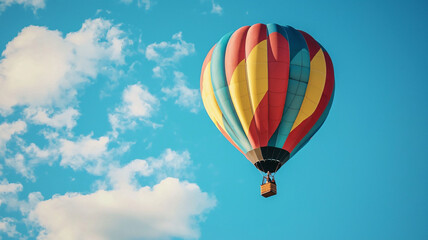 Naklejka premium Colorful Hot Air Balloon Flying Against Clear Blue Sky with Clouds