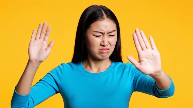 Young Asian Woman Holding Nose and Making Stop Gesture, Expressing Disgust and Unpleasant Smell.