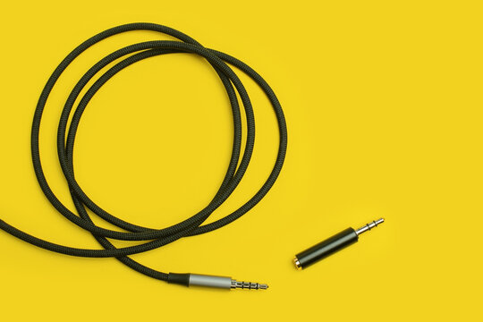 Audio cable with adapter trrs to trs on yellow backdrop