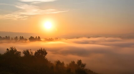 Fototapeta premium Golden sunrise illuminates a serene landscape covered in soft morning mist