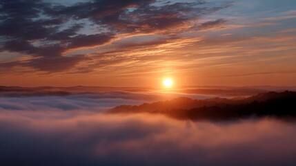 Fototapeta premium Golden sunrise breaks through mist over rolling hills under dramatic clouds