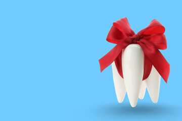 Decorative teeth with a red ribbon on a blue backdrop