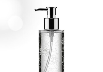 Obraz premium Elegant clear glass pump bottle with floral pattern and silver dispenser
