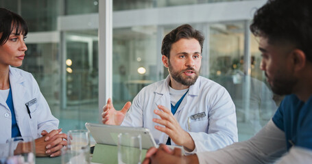 Obraz premium Nurse, doctors and tablet with discussion in hospital for case review, medical results and planning. Healthcare team, people and feedback with tech in clinic for workflow update or treatment options