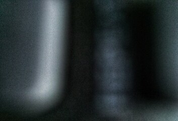 Abstract blurry dark grainy texture with soft glowing light