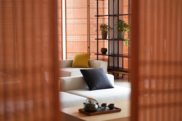 Cozy living room interior with white couch and wooden accents in warm lighting