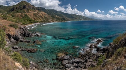 Panoramic View of Rocky Coastline with Turquoise Water and Lush Green Mountains Under Cloudy Blue Sky in Martinique