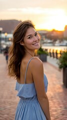 A pretty woman enjoying a city sunset, looking back at the camera with a smile. 