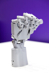 Mechanical plastic robot hand on purple and white background