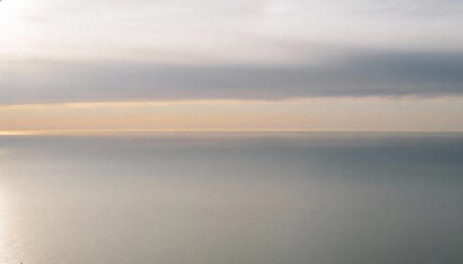 Serene Ocean Horizon at Dawn with Soft Clouds and Golden Light