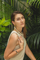 The portrait of beautiful brunette woman closeup on the green natural background with decorations. bali, indonesia