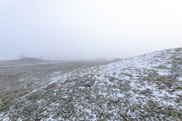 Mystische keltische Grabhügel im Winternebel bei Erkenbrechtsweiler. Verschneite historische Grabstätten am Heidengraben auf der Schwäbischen Alb in atmosphärischer Winterstimmung. © jiriviehmann