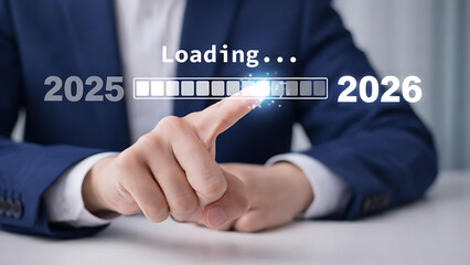 Professional in a suit pointing at a glowing progress bar loading the year 2026 from 2025 symbolizing technical preparation and future corporate strategic planning development