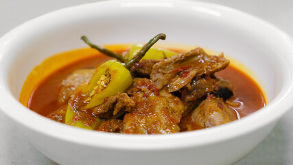Spicy Asian pork curry in white bowl