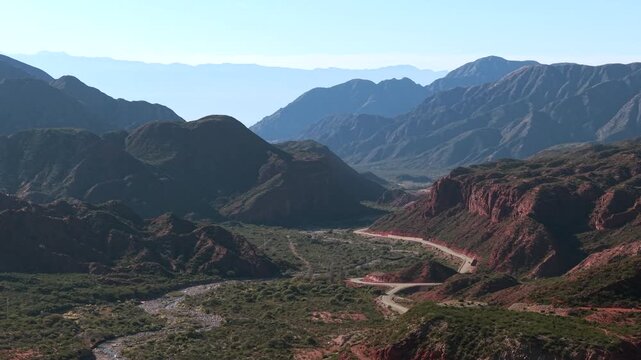 Cuesta de Miranda pass on Route RN 40 vibrant ochre and red tones of towering mountain slopes in La Rioja, Argentina, the slow motion shot allows detailed observation of folding and erosion patterns.