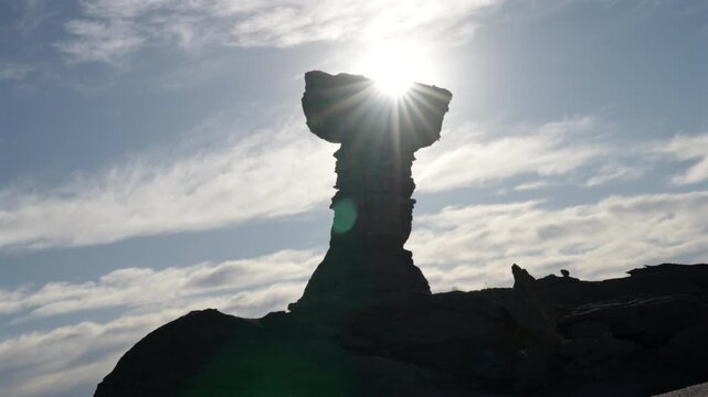 High-contrast static of El Hongo rock formation, silhouetted against a brilliant sunburst located in Ischigualasto Provincial Park Valle de la Luna UNESCO World Heritage Site in San Juan, Argentina