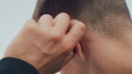 studio shot of man selfchecking ear, white male performing medical selfexamination of ear in studio, young man with light skin carefully inspecting his sore ear in clinical setting