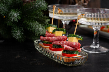 Canapes with salami, cheese, tomato. Christmas and New Year's dishes. Snacks and wine drinks for the holiday table.