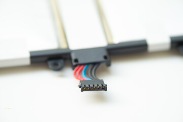 Close-up of a multi-pin battery connector with red, blue, and black wires. The component is part of a lithium polymer battery assembly for a mobile electronic device.