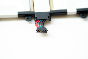 Close-up of a multi-pin battery connector with red, blue, and black wires. The component is part of a lithium polymer battery assembly for a mobile electronic device.