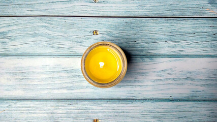 Aroma candle in a glass of natural soy wax on wooden background