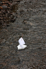 A Simple Homemade Ship Made Of Foam And Paper Floats On The Surface Of A Dark Creek. This Image Evokes Memories Of Childhood Games And Outdoor Adventure.