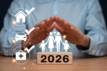 Hands forming a protective shield over a family icon resting on a block marked 2026 for financial planning.