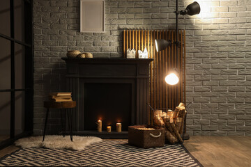 Fototapeta premium Interior of living room with glowing lamp, coffee table and firewood near fireplace in evening