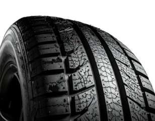 A close-up of a textured car tire with deep treads, isolated