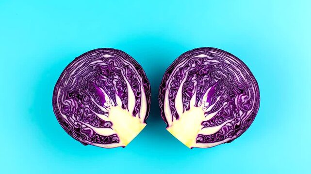 Two halves of a vividly colored, sliced vegetable with layers on a bright blue background