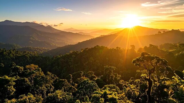 A vibrant sunset casts golden rays over lush, layered mountains and dense tropical forests