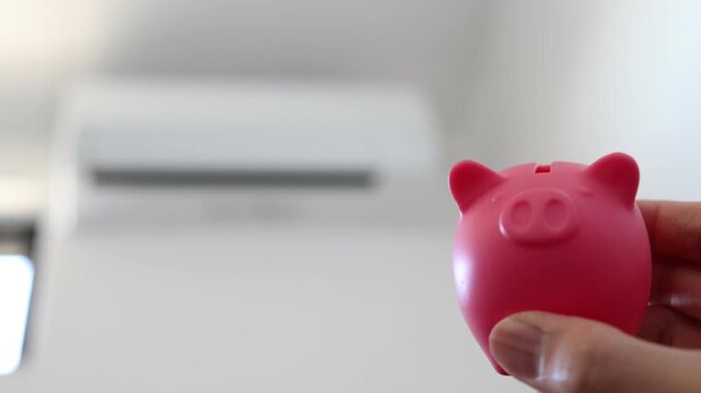 エアコンと豚の貯金箱を使った節電や電気代節約のイメージ。