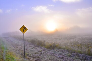 A Warning Sign in a Foggy Field at Sunrise in St-Ludger, Quebec, Canada